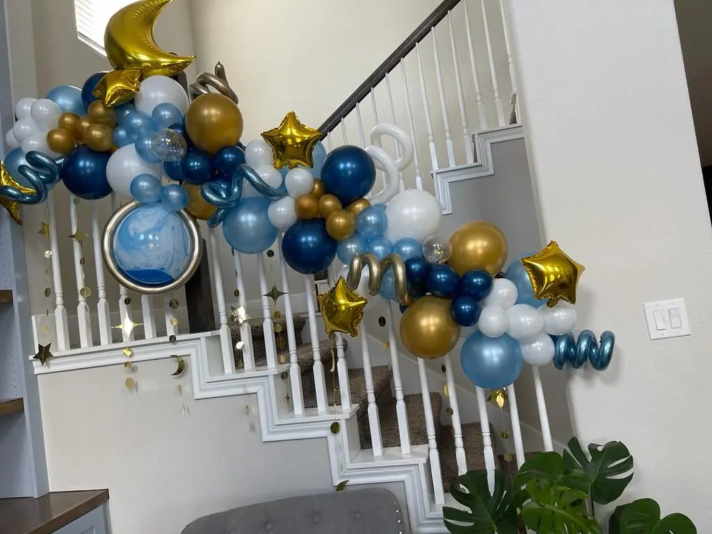 Navy, gold and silver balloon garland with stars and a moon running up a staircase