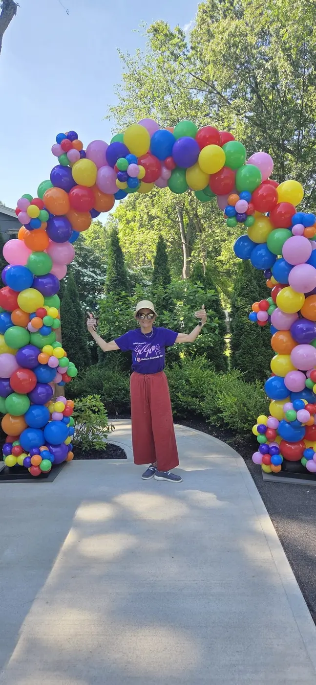 Rainbow balloon arch over a garden path for an end-of-school summer-splash party, balloon arch Rochester NY